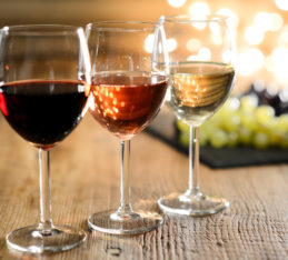 Wine and Weight Loss: three glasses of wine on table, grapes in background