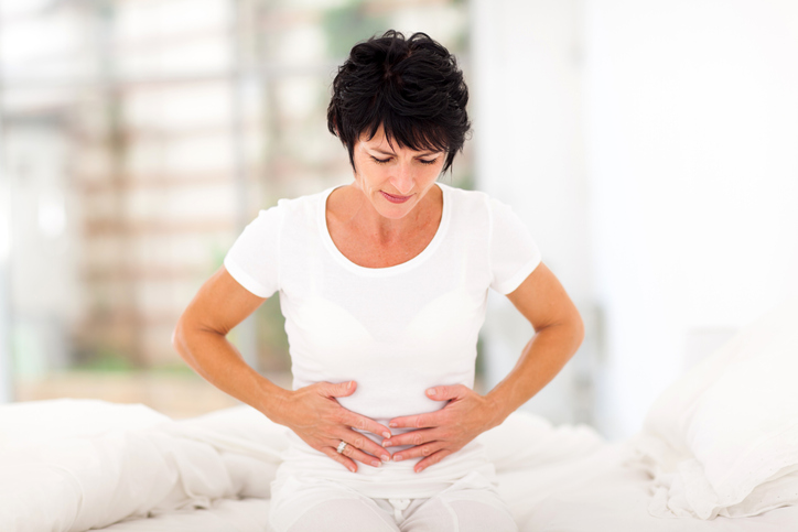 Hard to digest foods, worst foods for digestion: woman holding stomach in digestive pain